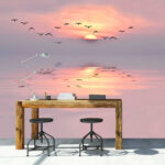 Wall murals Birds flying in the sky with the sun behind them