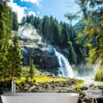 Wall murals Mountain waterfall amidst lush green forest.